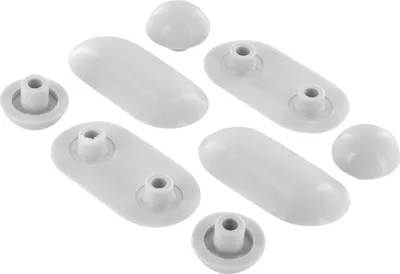 A collection of white plastic toilet seat buffers and caps arranged on a white background.