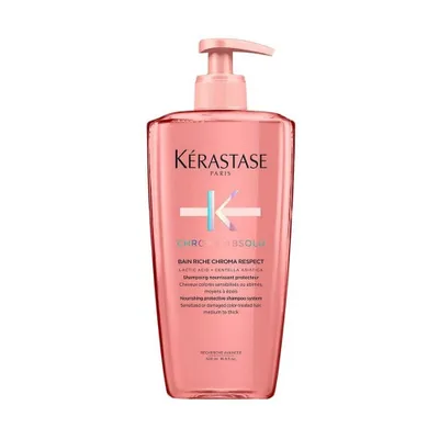 A pink bottle of Kerastase shampoo with a pump dispenser, isolated on a white background.