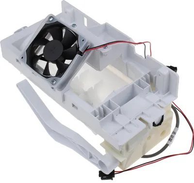 A white plastic component with a black fan attached, likely from a refrigerator or similar appliance.