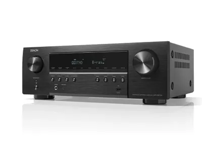 A black Denon AV receiver is shown from a three-quarter front view against a white background.