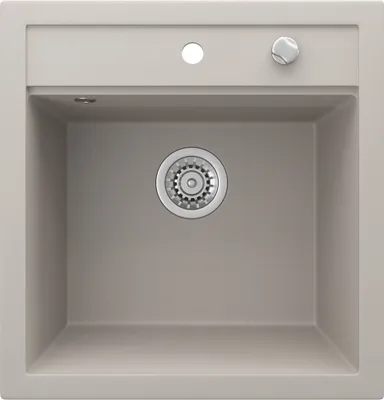 A top-down view of a beige sink with a drain and faucet knob.