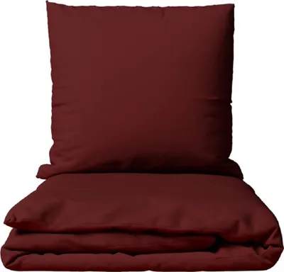 A folded duvet and pillow in a solid bordeaux color, presented on a white background.