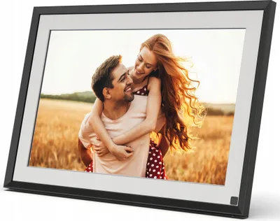 A digital photo frame displaying a couple in a field.