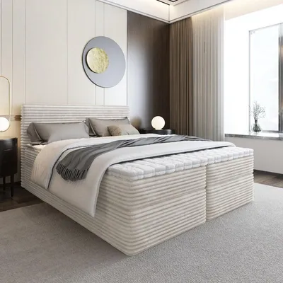 A modern bedroom with a large beige upholstered box spring bed.