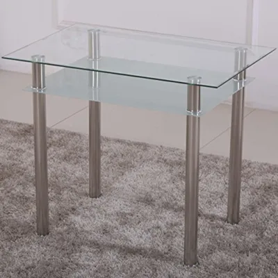 A glass table with metal legs on a rug.
