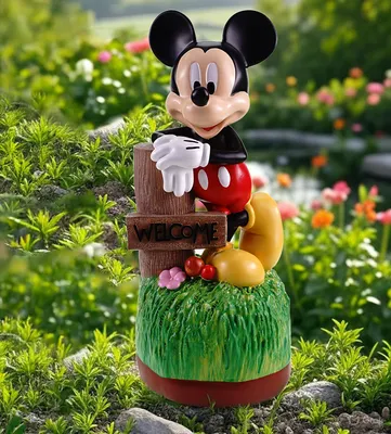 Mickey Mouse garden figurine with a welcome sign, placed in a garden setting with flowers and greenery.