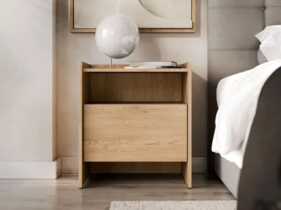A wooden nightstand next to a bed in a bedroom.