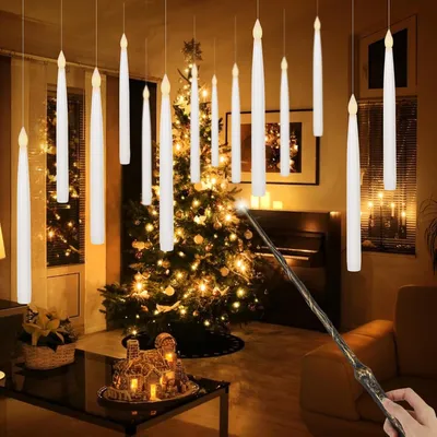 A festive indoor scene with hanging LED candles and a decorated Christmas tree.