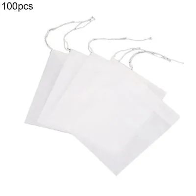 A stack of white, square filter bags with drawstrings, on a white background.