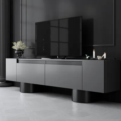 A modern TV stand with a television on top, set against a dark wall.