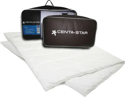 A white duvet is laid out in front of two branded bags, one black and one brown, on a white background.