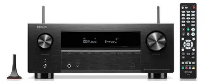 A black AV receiver with a remote control and an antenna.