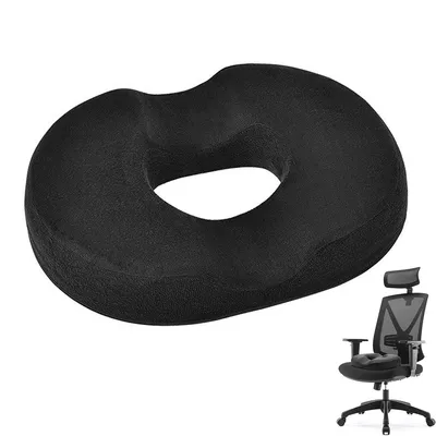 A black donut-shaped cushion is shown against a white background. A small inset image shows the cushion placed on an office chair.