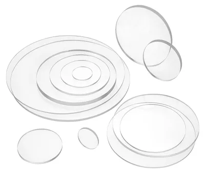 A collection of transparent acrylic discs of various sizes arranged on a white background.
