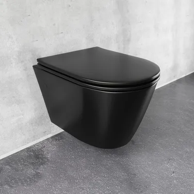 A black wall-mounted toilet against a concrete wall and floor.