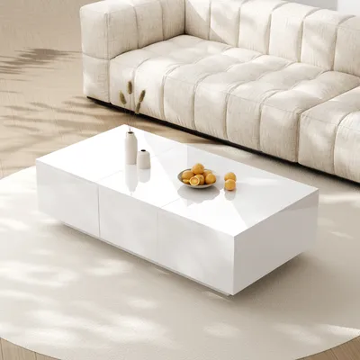 A modern living room scene with a white coffee table in the foreground and a beige sectional sofa in the background.