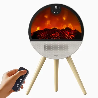 A hand holding a remote control is shown in the foreground, with a circular electric fireplace on a tripod stand in the background.