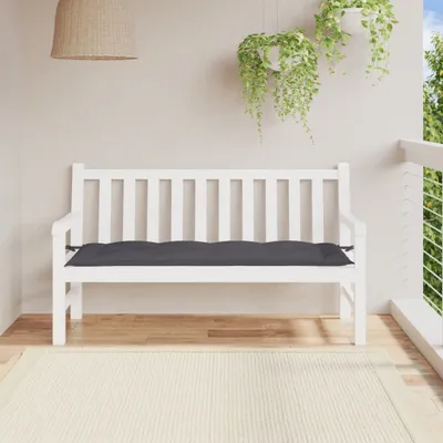 A white wooden garden bench with a dark gray cushion on a balcony or patio.
