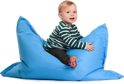 A young child sits on a large blue beanbag chair against a white background.