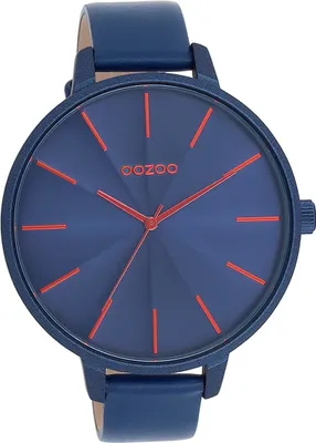 A close-up studio shot of a blue analog watch with red accents.
