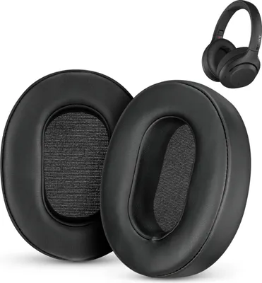 Two black ear pads for headphones are shown in the foreground, with a pair of black headphones in the background.