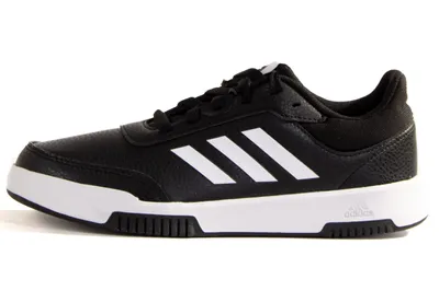 A side view of a black Adidas sneaker with white stripes on a white background.