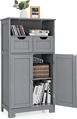 A gray wooden cabinet with two drawers and two doors, displaying books and decorative items.