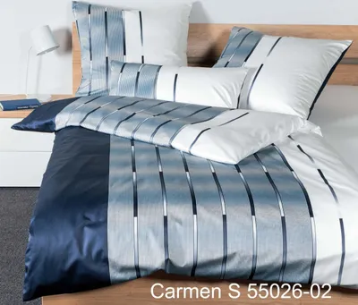 A neatly made bed with a duvet cover and pillows, featuring a striped pattern.