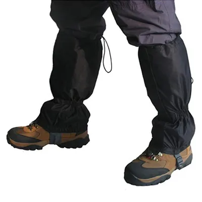 A person wearing black gaiters over their pants and hiking boots.