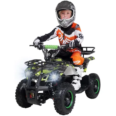 A young boy wearing motocross gear rides a green and black electric quad bike.