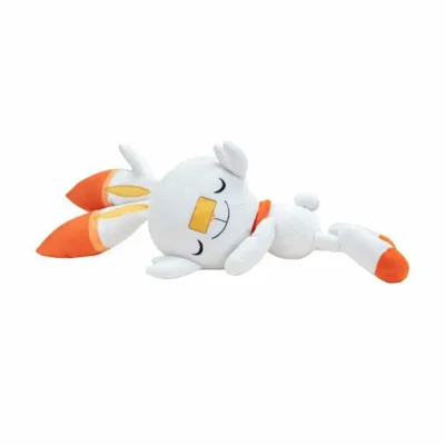 A plush toy of the Pokemon Scorbunny is lying on its side against a white background.