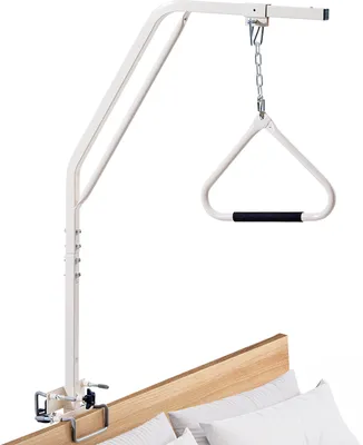 A white bed assist rail with a triangle handle is attached to the side of a bed.