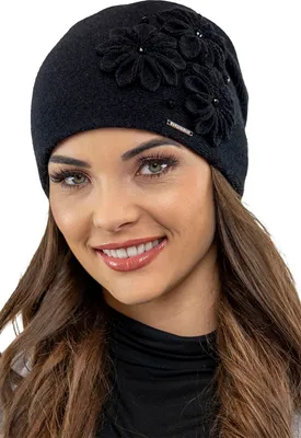 A woman wearing a black winter hat with floral embellishments.