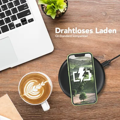 A flat lay of a laptop, a cup of coffee, and a smartphone charging wirelessly on a wooden desk.