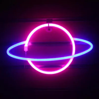 A neon light shaped like a planet with rings against a dark background.