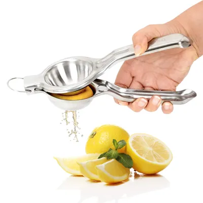 A person is using a stainless steel lemon squeezer to juice a lemon, with several lemons and mint leaves on a white background.