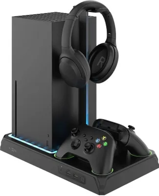 A black gaming console stand with a headset and two controllers on it.