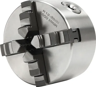 A close-up, studio shot of a four-jaw chuck for a lathe or milling machine.