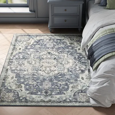 A bedroom scene with a rug, nightstand, and bed.