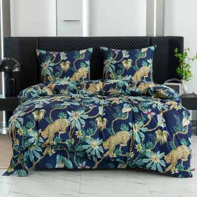 A bed with a duvet cover and pillowcases featuring a jungle print with leopards and tropical plants.