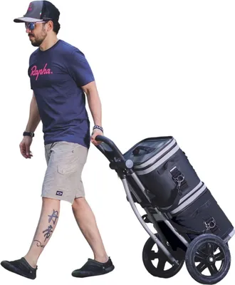 A man is pulling a shopping trolley with a cooler bag attached.