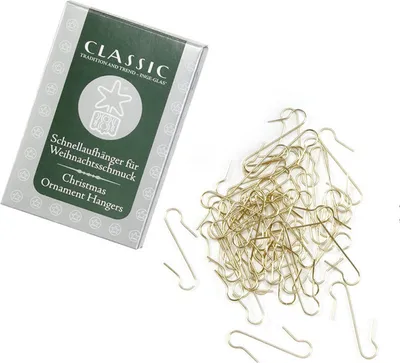 A box of Christmas ornament hangers and a pile of gold-colored metal hangers on a white background.