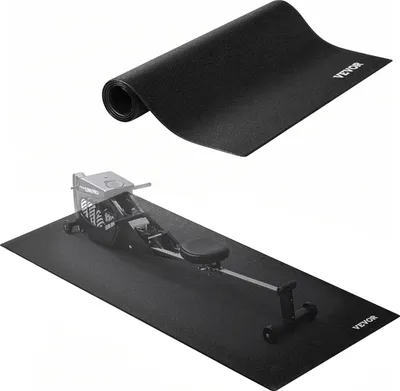 A black exercise mat is shown, both rolled up and unrolled with a rowing machine on top.