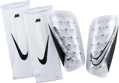 A pair of white Nike shin guards with black Nike swoosh logos and text.