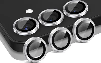A close-up view of several camera lens protectors arranged on a dark surface, likely a smartphone.