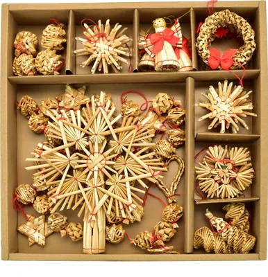 A collection of straw ornaments arranged in a cardboard box.