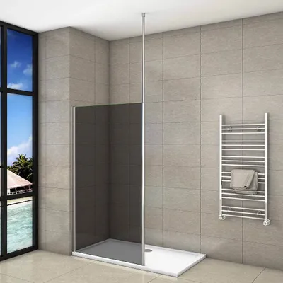 A modern bathroom with a walk-in shower, a towel rack, and a large window overlooking a tropical scene.