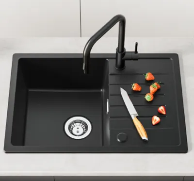 A black kitchen sink with a faucet, a cutting board, a knife, and strawberries.