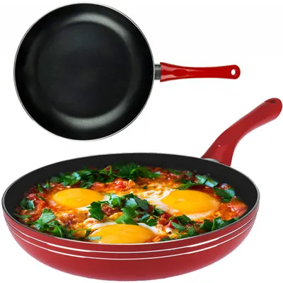 A frying pan with a red handle is shown, with a second frying pan in the foreground containing food.
