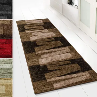 A runner rug with a geometric pattern is laid out on a white floor in front of white cabinets.